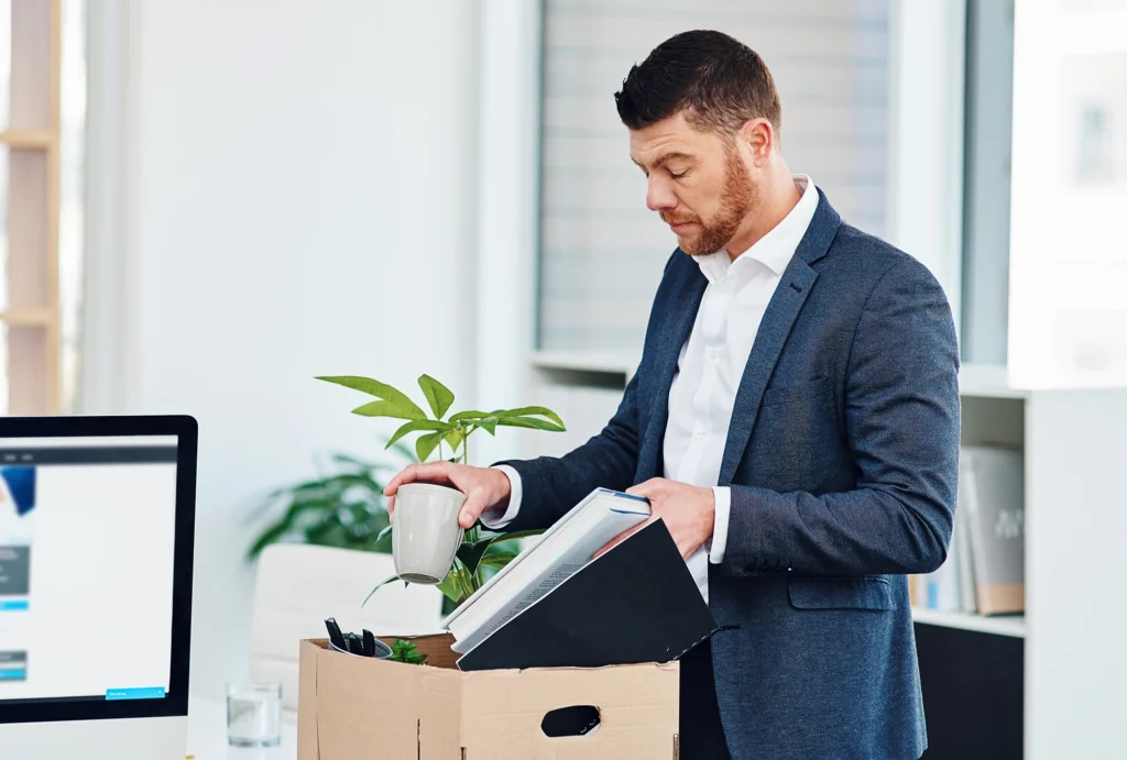 business professional packing his things in office after getting laid off