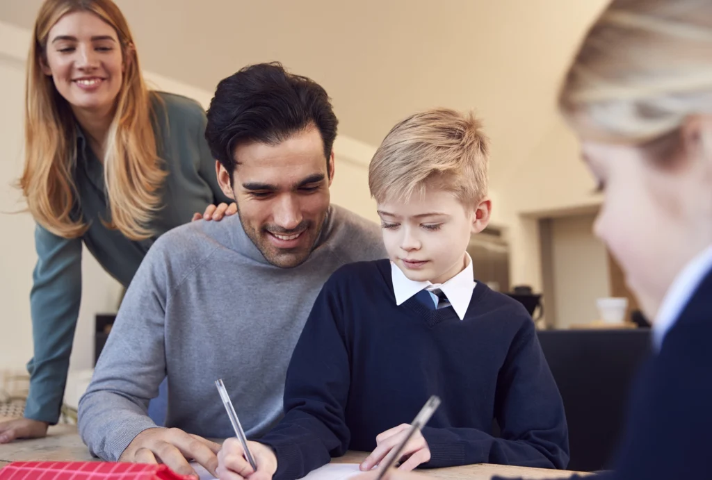 mother and father helping kids with homework at a table