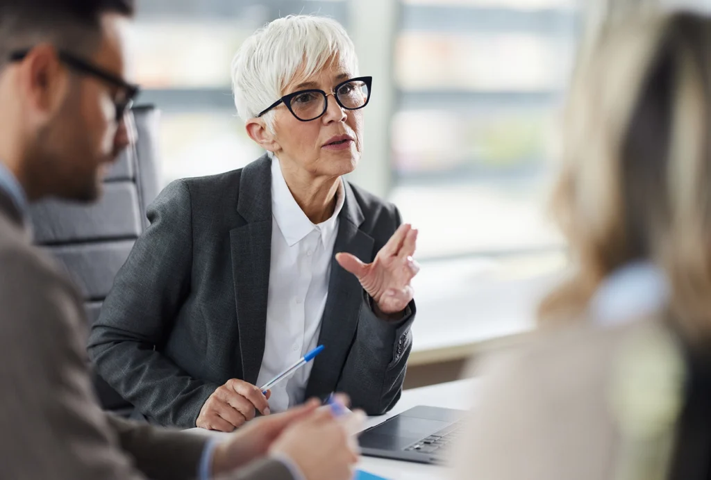 professional woman speaking to other people in a conference room