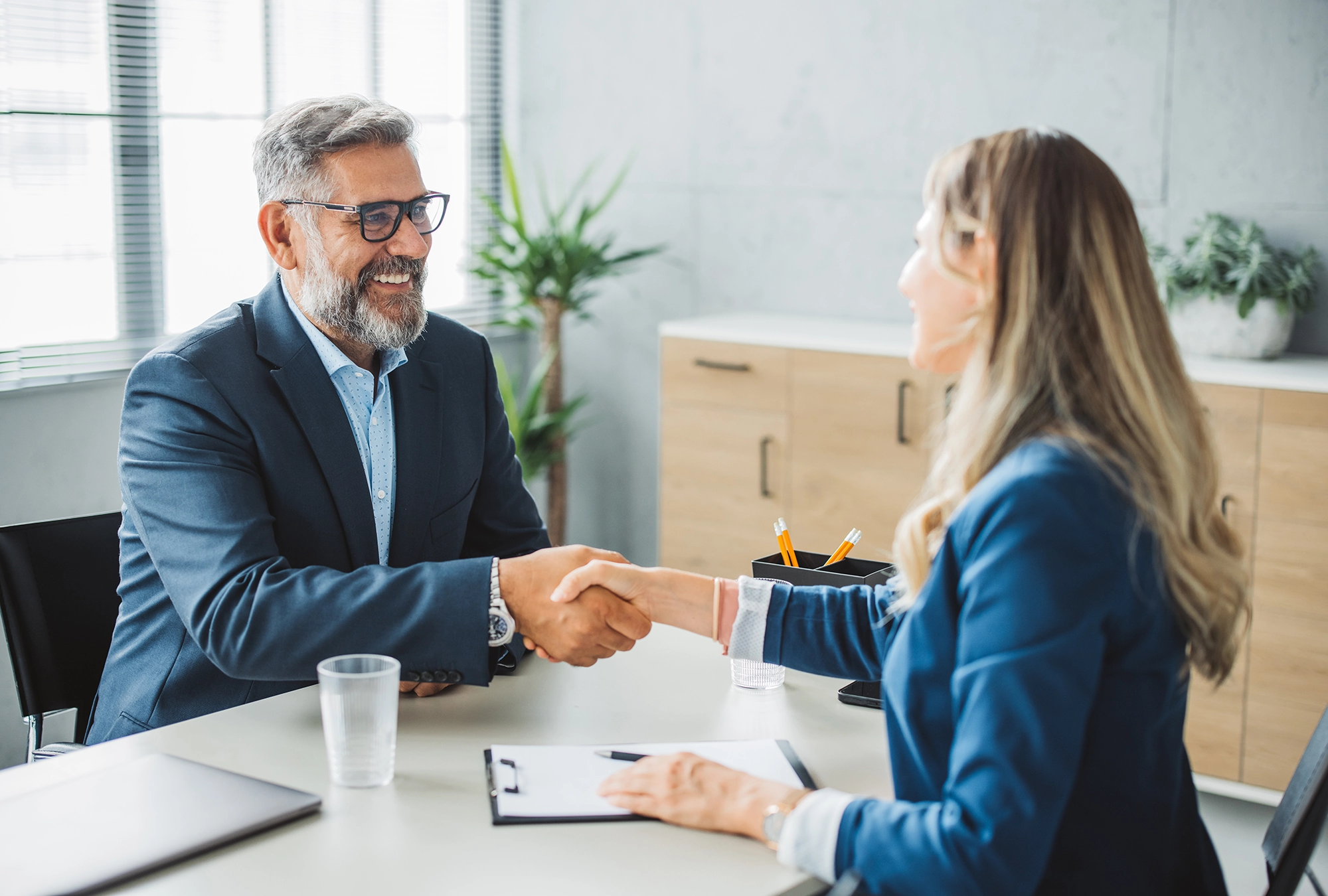 man meeting with a financial advisor in office, shaking hands